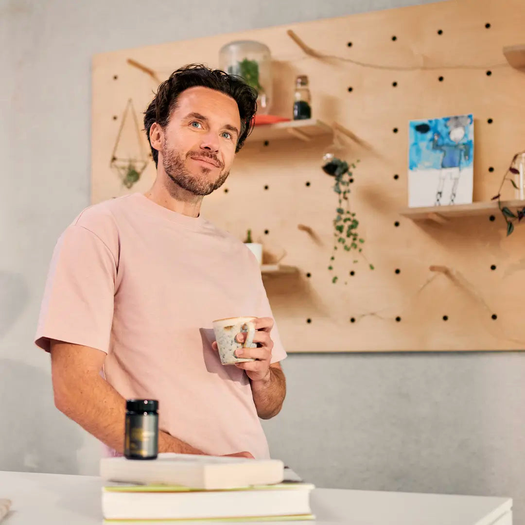 guy holding cap with spermidine bottle on the table