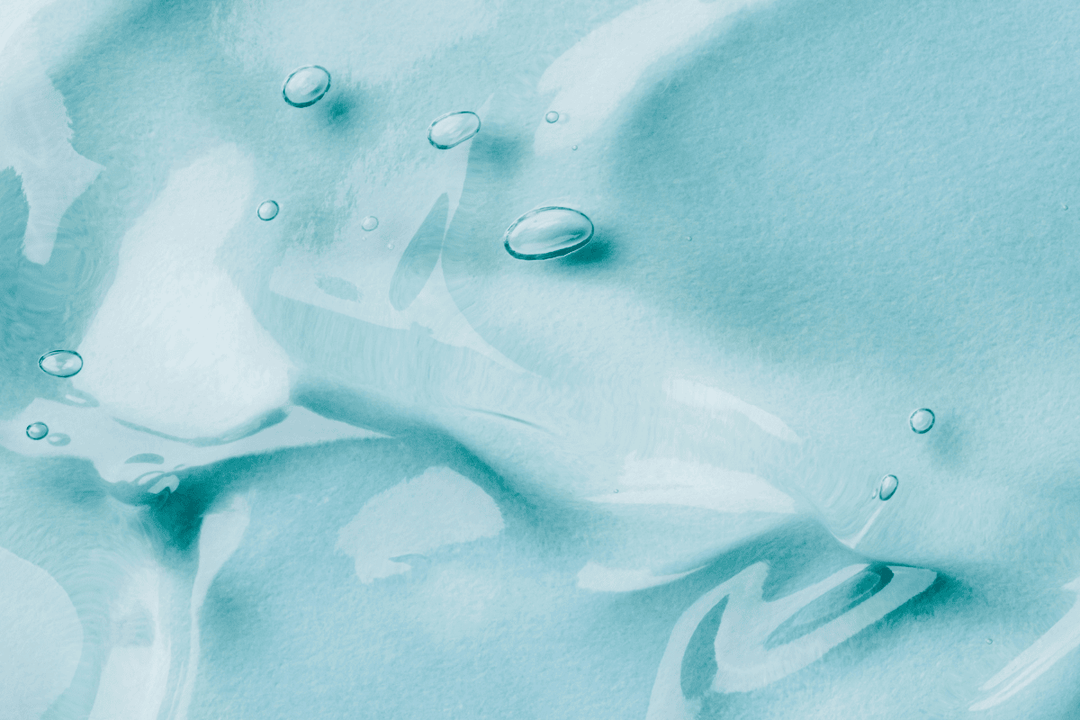 Clear hyaluronic acid liquid with soft reflections on a turquoise blue miamidolins background, symbolizing hydration and skin health