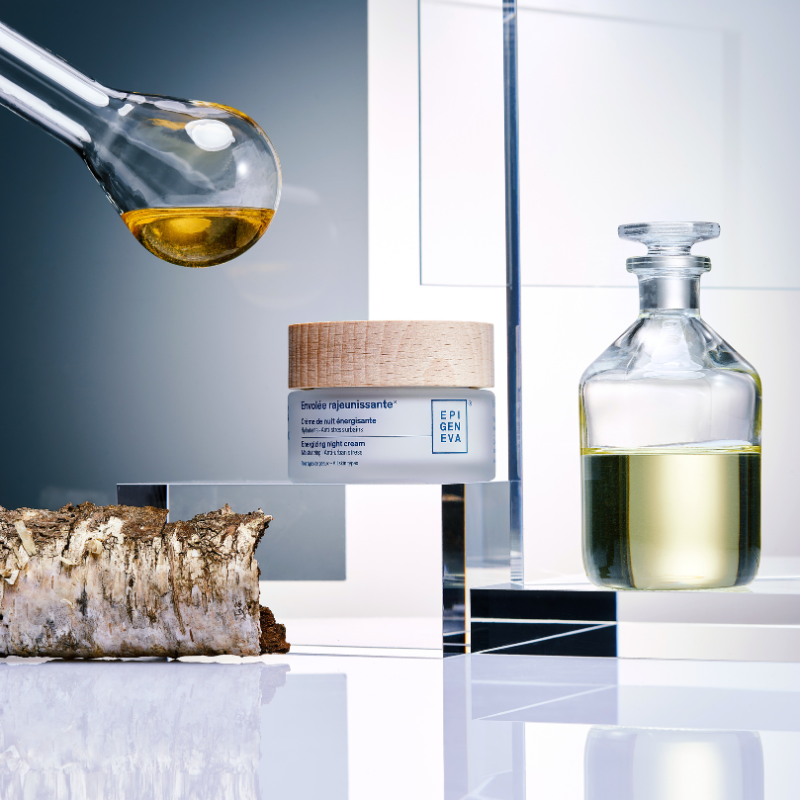 Cosmetic product with dropper and glass bottle on a reflective surface