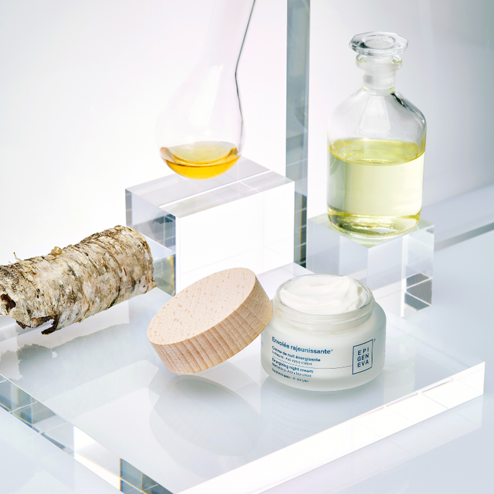 Cosmetic products including a jar, bottle, and root on a white surface with a neutral background