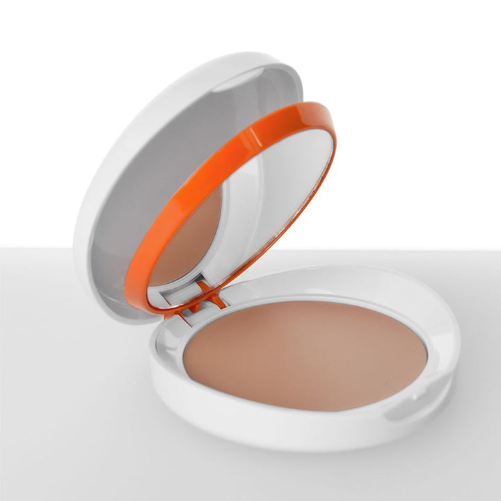 Compact powder with a mirror and orange accent on a white background light color