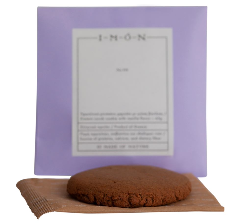 Chocolate cookie on a wooden board with a purple box in the background