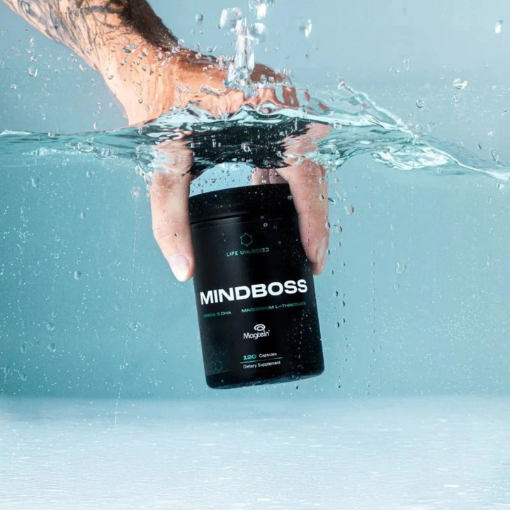 Hand holding a 'MINDBOSS' supplement container underwater with a light blue background