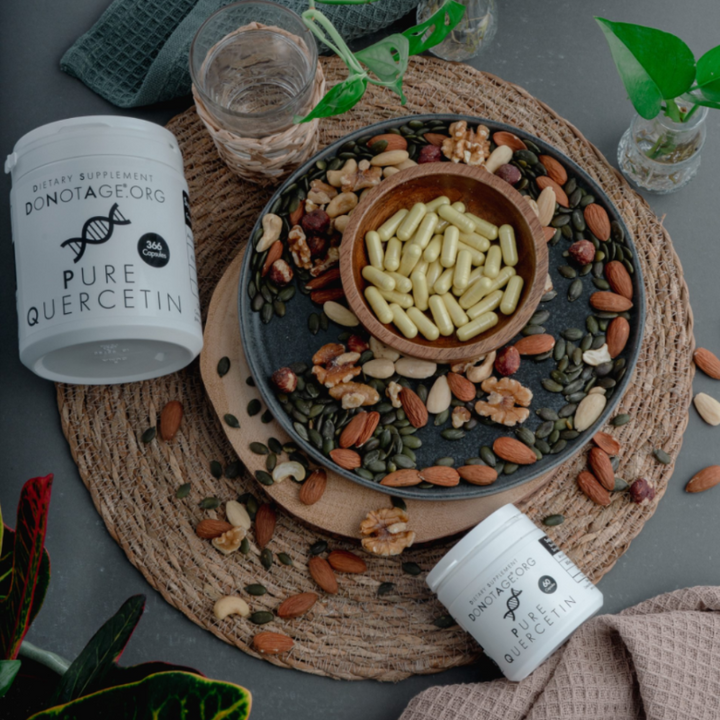 Nuts and seeds on a plate with a container of 'Pure Quercetin' supplement on a textured surface.